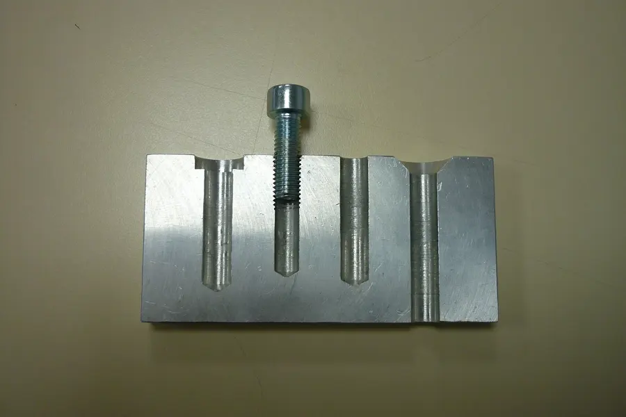 Machined metal block with drilled and tapped holes